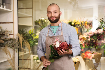 Professional florist with bouquet of fresh flowers in shop
