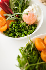 Vegetarian breakfast. Poached egg, arugula, tomatoes, green peas. 