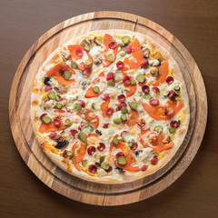 pizza on a round wooden Board top photo