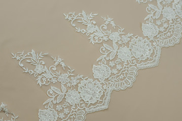 Texture lace fabric. lace on white background studio. thin fabric made of yarn or thread. a background image of ivory-colored lace cloth. White lace on beige background.