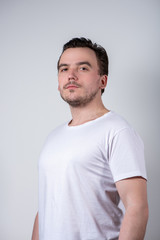 Fototapeta premium Handsome man with bristles in white t-shirt smiling
