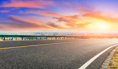 Shanghai city skyline and empty asphalt road scenery at sunset.