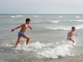 Children swim in the sea on the beach in Bibione, Italy