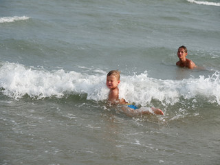 Children swim in the sea on the beach in Bibione, Italy