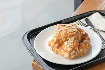 Almond cream croissant in white plate.