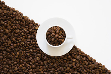 white cup on coffee beans on a white background, top view