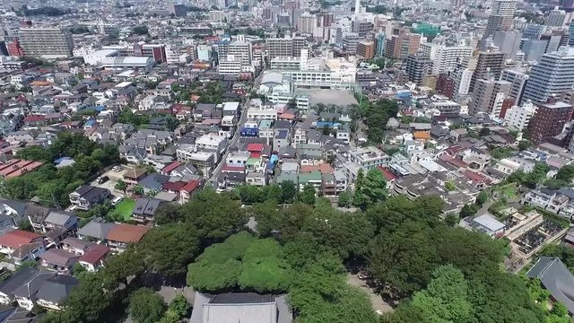 Flying by drone over a Tokio tempel at a summer day.