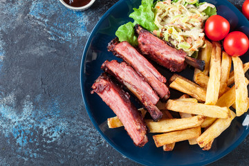 Spicy barbecued pork ribs served with french fries