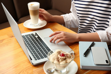 Obraz na płótnie Canvas Blogger working with laptop in cafe, closeup