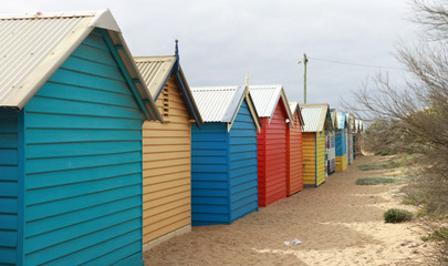 views of rows of colourful beach bright painted summer holiday bathing box's along a sandy beach on a sunny day, Brighton beach, Melbourne Victoria