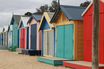 views of rows of colourful beach bright painted summer holiday bathing box's along a sandy beach on...