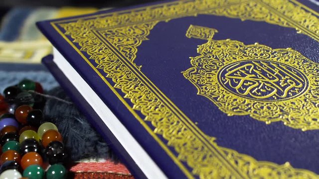 Slow Pan Rotating shot of Holy Quran Muslims Holy Book Quran Kareem with Colorful Tasbeeh Paternoster 4K