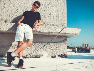 Young attractive man posing in front of camera on the roof of a residential building