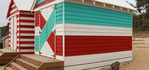views of rows of colourful beach bright painted summer holiday bathing box's along a sandy beach on...