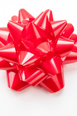 Close-up of large shiny bright red gift bow in on white background