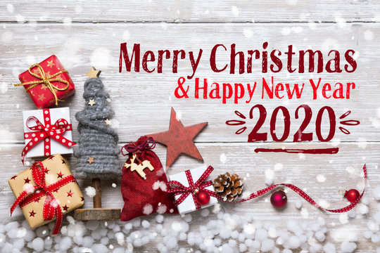 Merry Christmas and Happy New Year 2020 - Christmas Greeting Card 2019, 2020 - Xmas Decoration with gift boxes and ornaments on light rustic wood