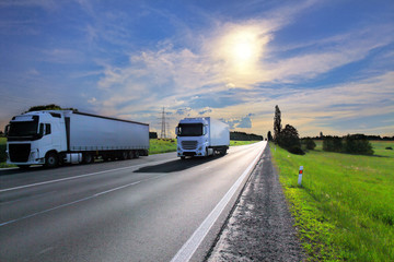 White trucks transport on the road at sunset and cargo 