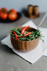 Red pepper, salad and arugula in a wooden plate