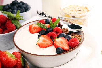 Tasty homemade granola served on table. Healthy breakfast with a bowl of oatmeal with banana, blueberries, strawberries and healthy food for Breakfast