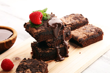 chocolate brownie cake dessert with raspberries and spices on a wooden background.