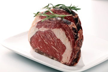 Raw fresh meat Ribeye Steak, seasoning and meat fork on rustic background