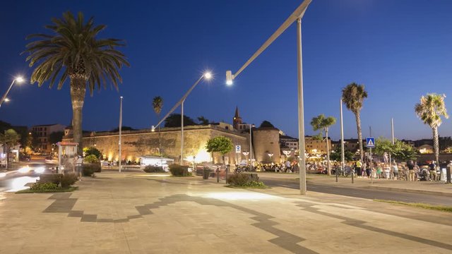 Night view of the historic center with the bustling city life of the city of Alghero in Sardinia, Italy.