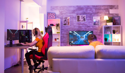 Friends playing video games in a room with neon light © DC Studio