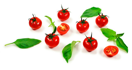 Ripe red tomatoes with basil leaves isolated on a white background.