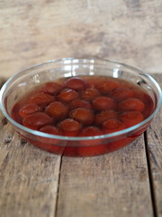 plum drink in a glass plate on a wooden background