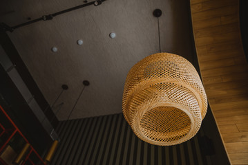 stylish large chandelier on the ceiling in the cafe. wooden wicker chandelier lamp shade For the...