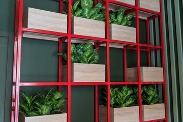 Stylish shelves with decorative elements. For concept, design.red shelf with green flowers Modern restaurant style. color contrast in the interior