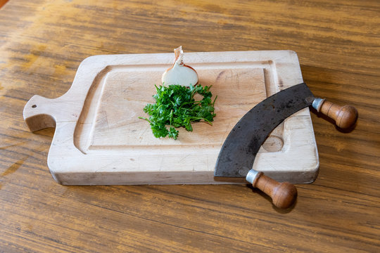 Onion, Parsley And Chopper On A Wooden Board In A Kitchen