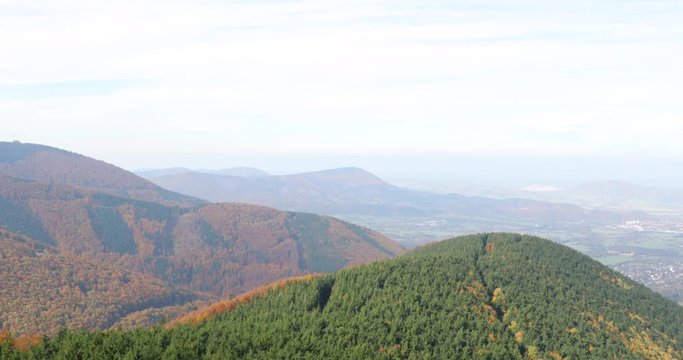 Hills and mountains on the horizon of a beautiful nature forest view into the vast distance of the Beskids Protected Area during a windy sunny day captured in Radhost Pustevny area 4k 60fps.