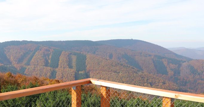 Wooden sky walk top point with view to landscape during a strong wind in the background with moving trees inside forest and hills as background in horizontal captured in Beskids area 4k 60fps.