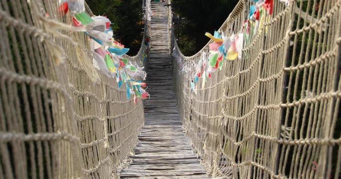 Flying colored flags on Himalayan sidewalk, deep in nature Skywalk wooden construction&nbsp; hitting by strong wind tree&nbsp; a sunny, strong wind, autumn day captured in Radhost Pustevny area 4k 60fps
