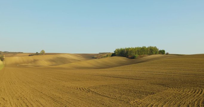 The rotational movement of plowed land after the season in the Moravian Tuscany region a landscape full of ripples overlooking two different fields during an afternoon sunny day capture in 4k 60fps.