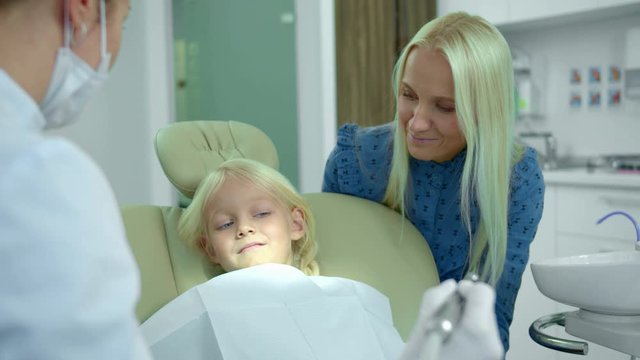 Dentist shows to a girl how a medical drill works