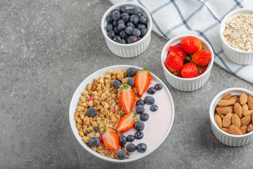 Granola with yogurt fresh strawberries and blueberries on a stone table. Healthy snack. The food for Breakfast. Top view.