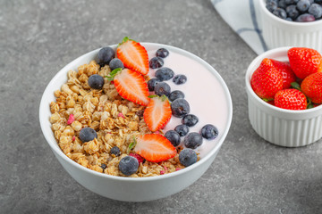 Granola with yogurt fresh strawberries and blueberries on a stone table. Healthy snack. The food for Breakfast. 