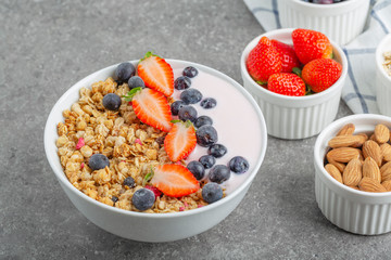 Granola with yogurt fresh strawberries and blueberries on a stone table. Healthy snack. The food for Breakfast. 
