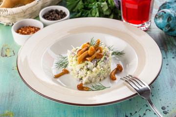 salad with honey mushroom and potato and glass of red drink on blue wooden table