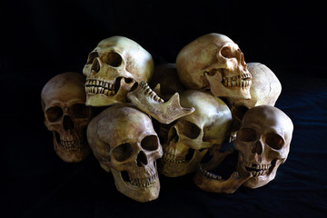 Awesome, pile of skull and bone, on black background and black cloth floor