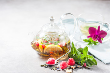 Hot herbal tea with lemon, raspberries and mint. Healthy lemon tea.