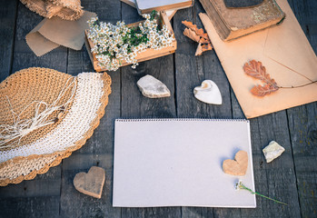 Notebook blank page mock-up and vintage objects on rustic wooden table. Vintage autumn mockup background. Mock up top view. Toned image in retro style.