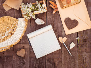 Notebook blank page mock-up and vintage objects on rustic wooden table. Vintage autumn mockup background. Mock up top view. Toned image in retro style.