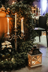 Table decoration with burning candles, white flowers. Romantic Christmas or party atmosphere.