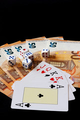 POKER CARDS, DICE AND MONEY ON BLACK BACKGROUND. TABLE SET WITH BETS