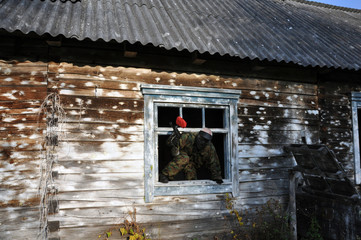 Active paintball game. Dekation of the playing field, a wooden house serves as a shelter for the player.