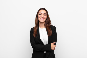 young pretty businesswoman laughing shyly and cheerfully, with a friendly and positive but insecure...