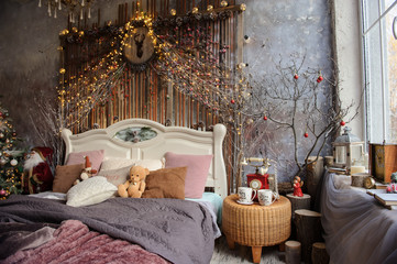 Fototapeta premium lateral view of a decorated room for winter holidays with a white bed near a large window and a Christmas tree